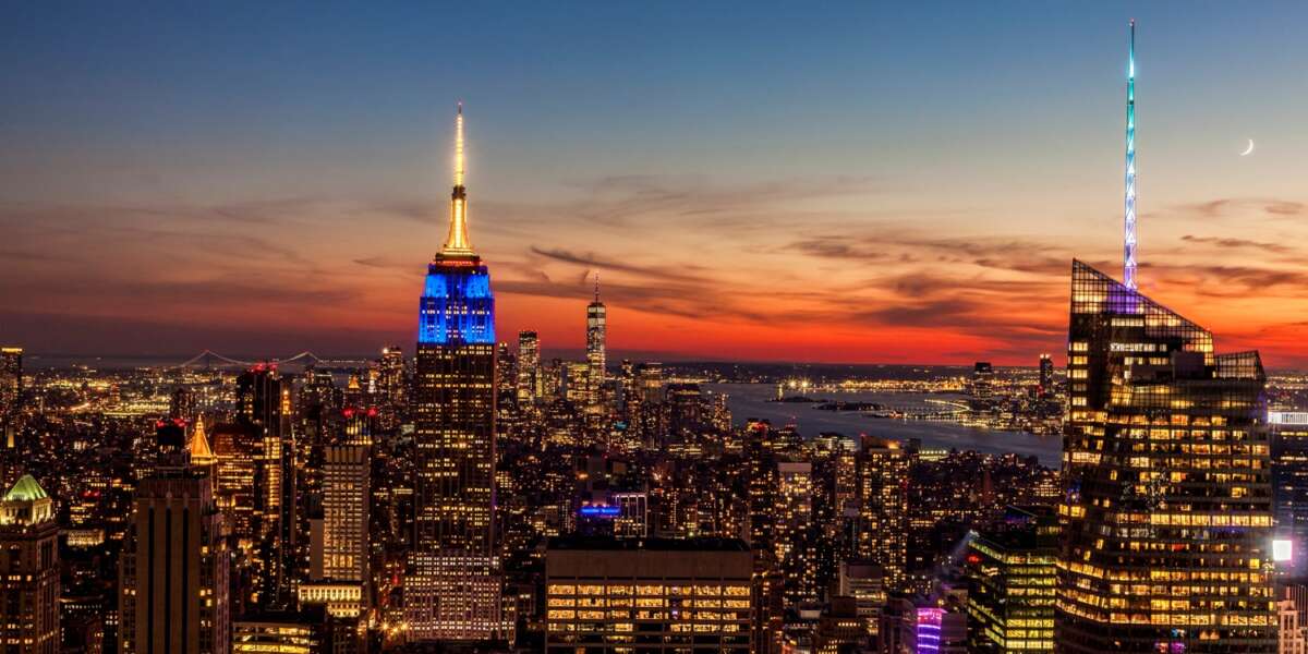 View of Manhattan looking out over the Empire State Building, One World Trade Center and the Statue of Liberty