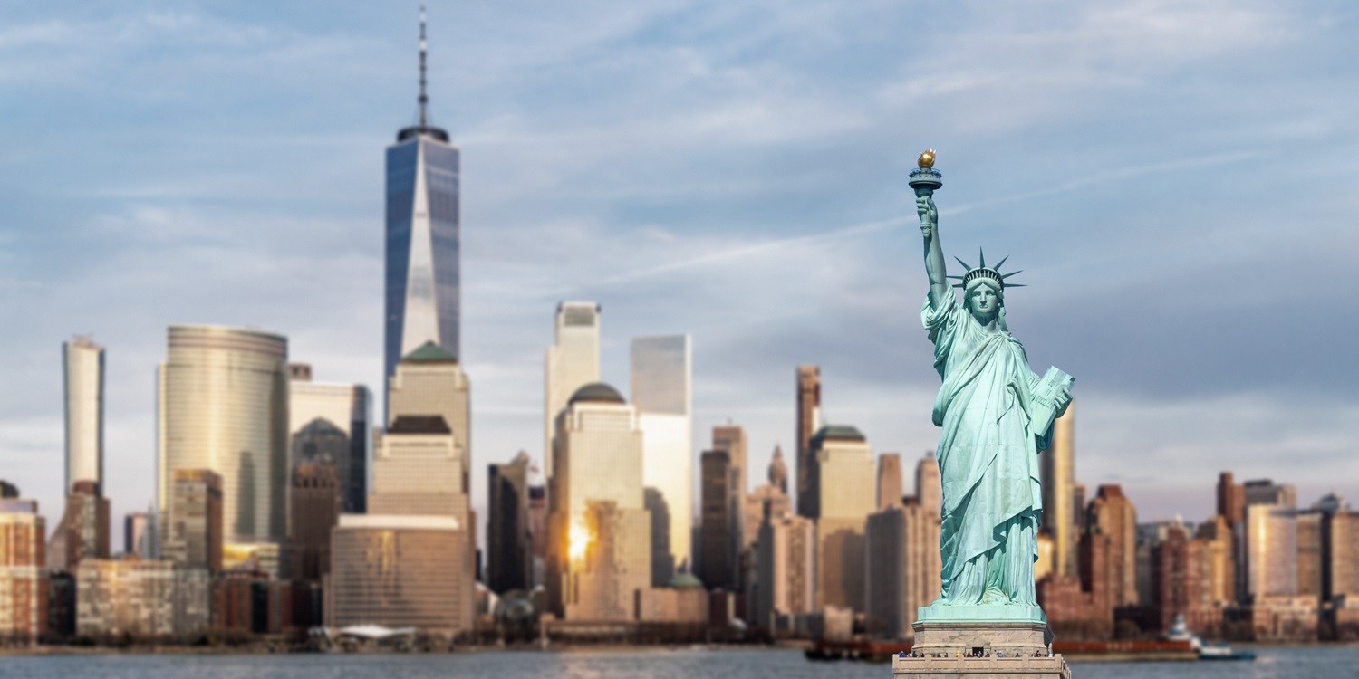 Statue of Liberty with background of New York city Manhattan skyline cityscape at sunset from New Jersey.