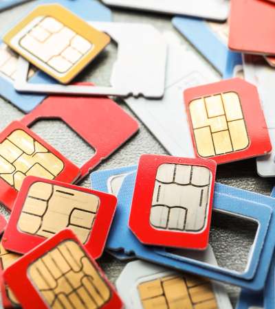 Many sim cards on grey background, closeup