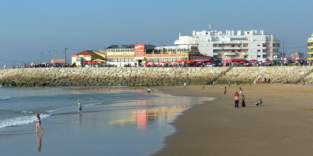 Costa de Caparica beach bars - <a href="https://commons.wikimedia.org/wiki/File:Costa_de_Caparica_-_panoramio_-_singra13.jpg">singra13</a>, <a href="https://creativecommons.org/licenses/by-sa/3.0">CC BY-SA 3.0</a>, via Wikimedia Commons