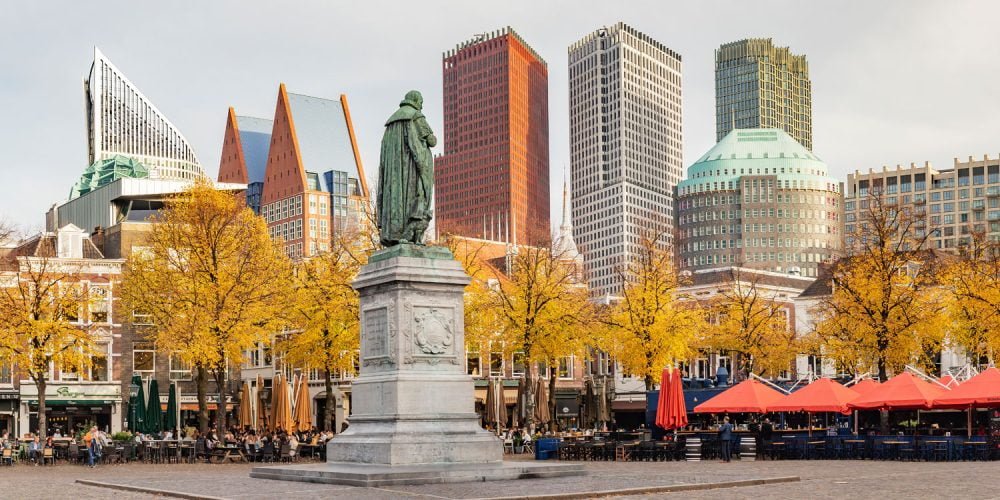 Panorama photo of the statue of William of Orange on het Plein in the Hague in autumn tones with the sky-line in the background