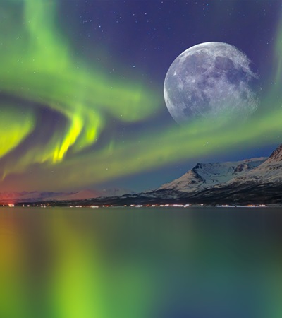 Northern lights (Aurora borealis) in the sky over Tromso with full Moon