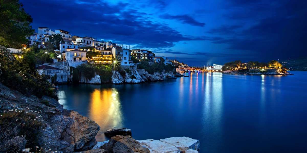 Night view of Plakes, the oldest neighborhood of Skiathos town. To the right, you can see Bourtzi castle.  Skiathos island, Northern Sporades, Greece.