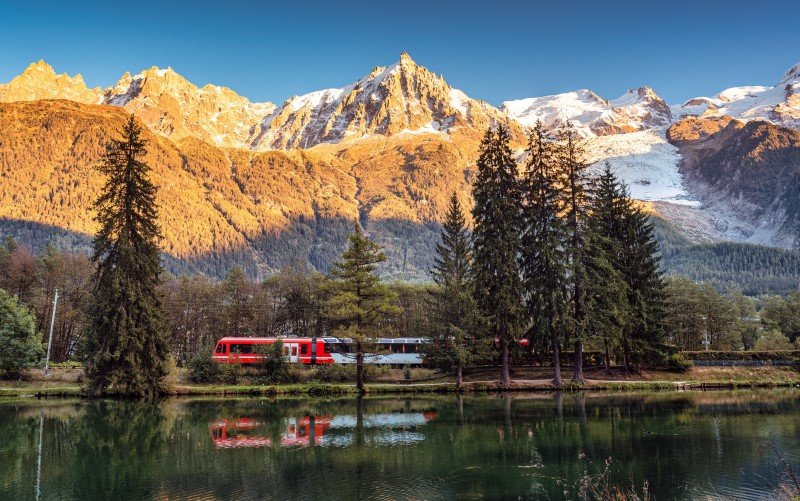 Lac des Gaillands with train passing and Mont Blanc massif reflection in the sunset at Chamonix, France